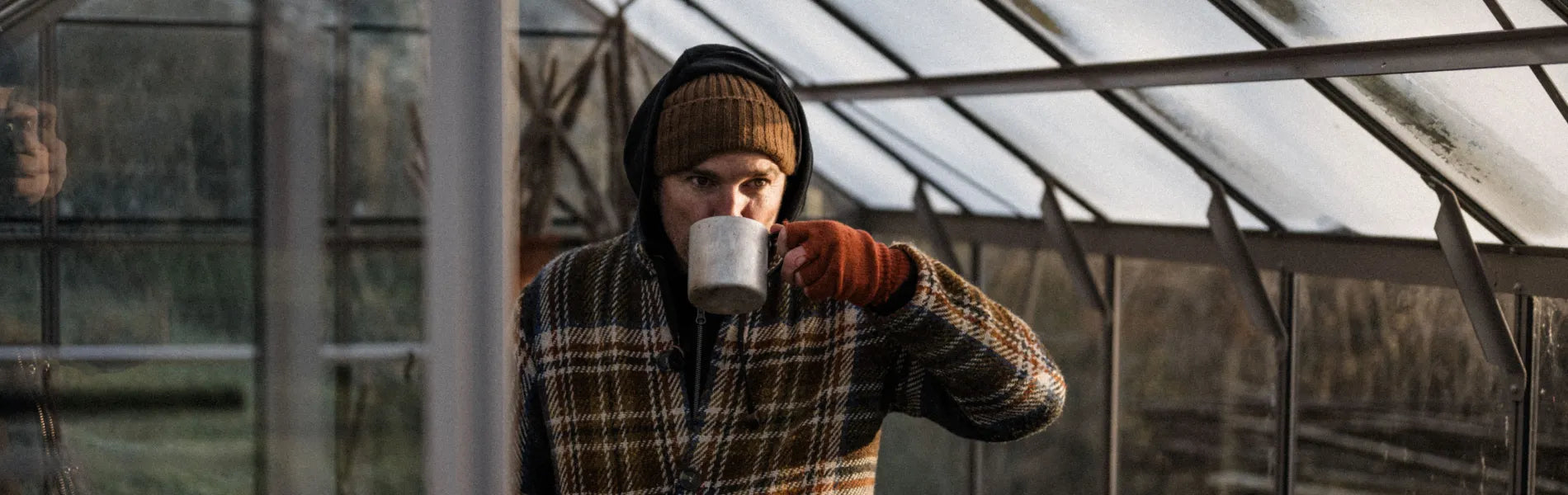 Gill drinking a hot drink in his Rhino greenhouse